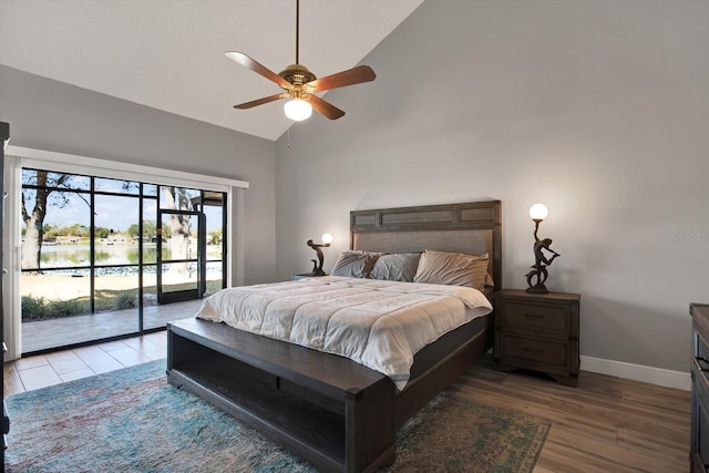 bedroom with hardwood / wood-style flooring, high vaulted ceiling, access to outside, and ceiling fan