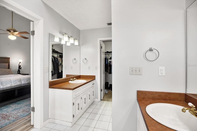 bathroom featuring ceiling fan, tile patterned floors, vanity, and a textured ceiling