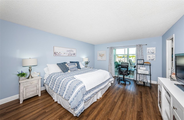 bedroom with dark hardwood / wood-style flooring and a textured ceiling