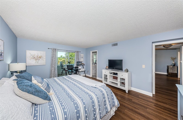 bedroom featuring dark hardwood / wood-style flooring, access to outside, and a textured ceiling