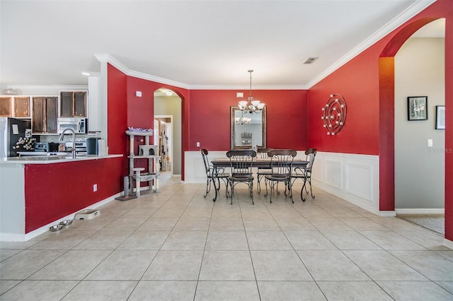 dining area with crown molding, light tile patterned flooring, and a notable chandelier