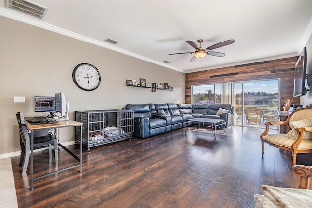 living room with ceiling fan, ornamental molding, dark hardwood / wood-style flooring, and wood walls