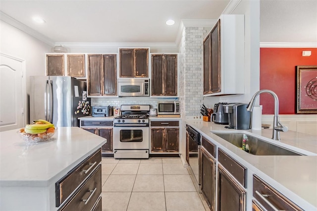 kitchen with sink, crown molding, light tile patterned floors, appliances with stainless steel finishes, and backsplash