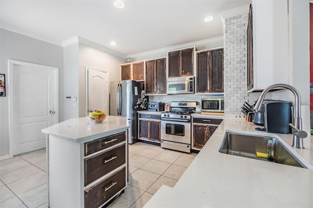 kitchen with light tile patterned flooring, sink, backsplash, ornamental molding, and stainless steel appliances