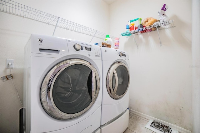 washroom with washing machine and clothes dryer and light tile patterned flooring