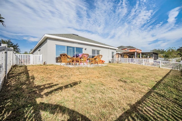 rear view of property with a yard and a patio area