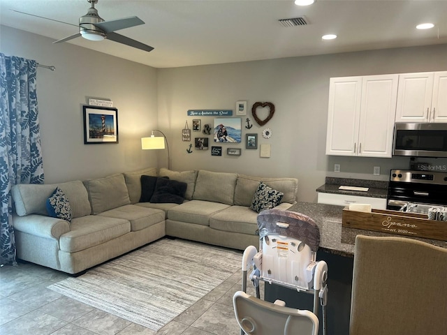 tiled living room featuring ceiling fan