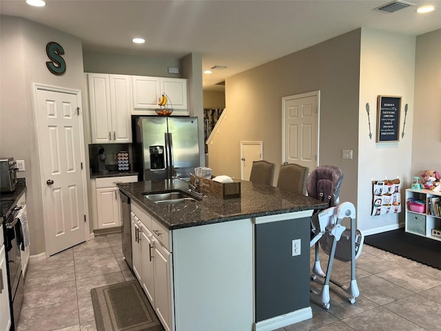 kitchen featuring an island with sink, appliances with stainless steel finishes, and white cabinets