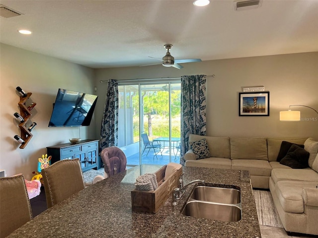 living room with ceiling fan and sink