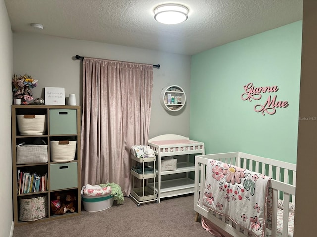 carpeted bedroom with a textured ceiling and a crib