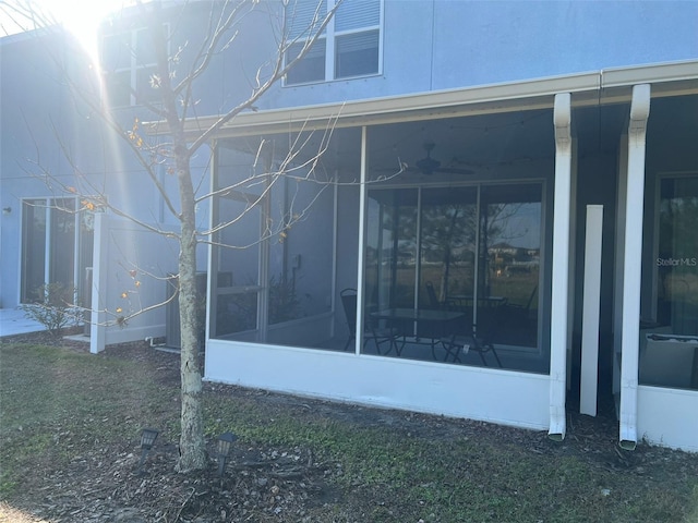 view of side of property featuring a lawn and a sunroom