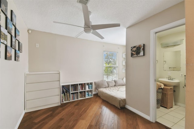 unfurnished room with ceiling fan, hardwood / wood-style flooring, and a textured ceiling