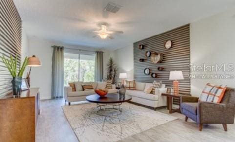 living room with ceiling fan and light hardwood / wood-style flooring