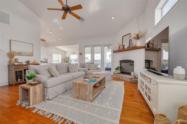 living room with high vaulted ceiling, ceiling fan, and light hardwood / wood-style flooring