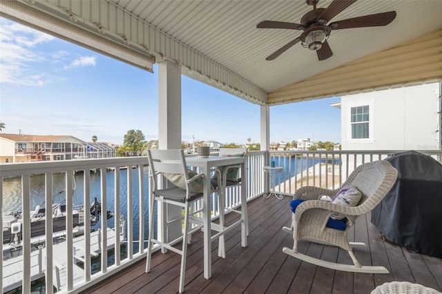 wooden deck featuring a pool, grilling area, a water view, and ceiling fan