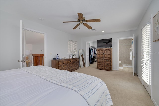 carpeted bedroom featuring multiple windows, ensuite bathroom, ceiling fan, and a closet