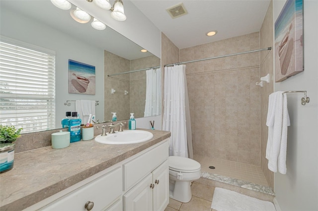 bathroom with tile patterned flooring, vanity, a healthy amount of sunlight, and walk in shower