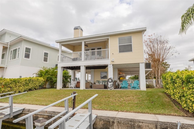 back of property featuring a yard, outdoor lounge area, a patio, and a balcony