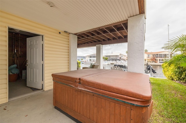 view of patio / terrace featuring a hot tub and a water view