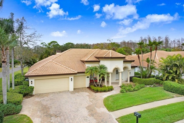 mediterranean / spanish house with a garage and a front yard