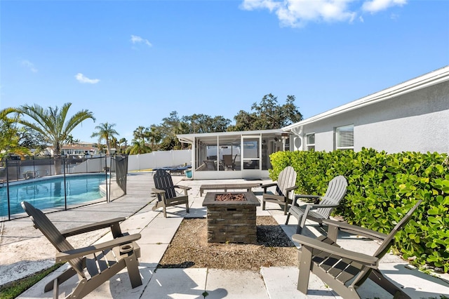 view of patio featuring an outdoor fire pit, a fenced in pool, and a sunroom