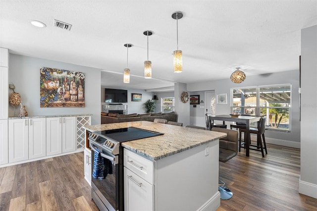 kitchen featuring electric range, decorative light fixtures, dark hardwood / wood-style floors, and white cabinets