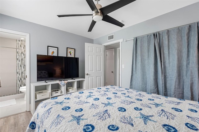 bedroom featuring light wood-type flooring, ceiling fan, and ensuite bathroom