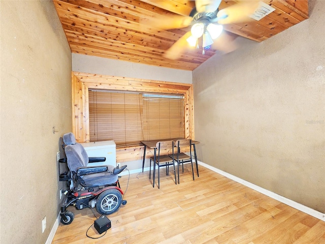 living area featuring a textured wall, ceiling fan, wooden ceiling, and wood finished floors