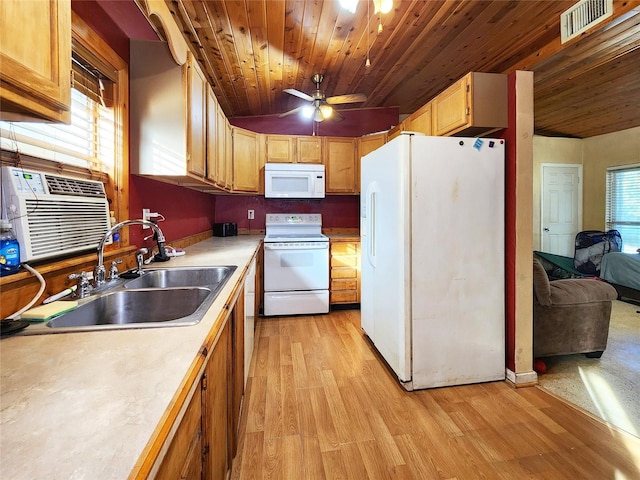 kitchen with light wood-type flooring, white appliances, light countertops, visible vents, and a sink