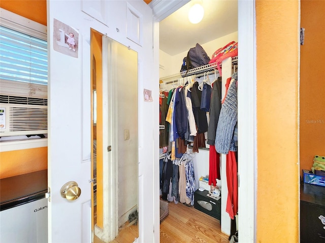 spacious closet featuring cooling unit and wood finished floors