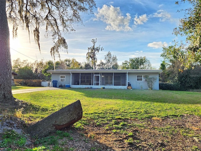 rear view of property with a sunroom, a yard, and stucco siding