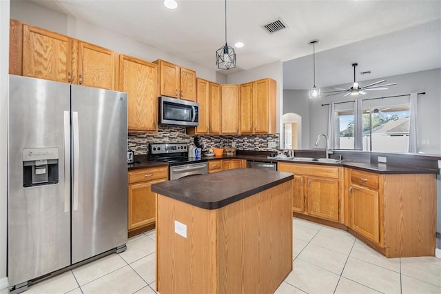 kitchen featuring pendant lighting, sink, appliances with stainless steel finishes, a center island, and kitchen peninsula