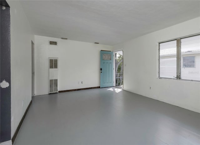 empty room with concrete flooring and a wealth of natural light