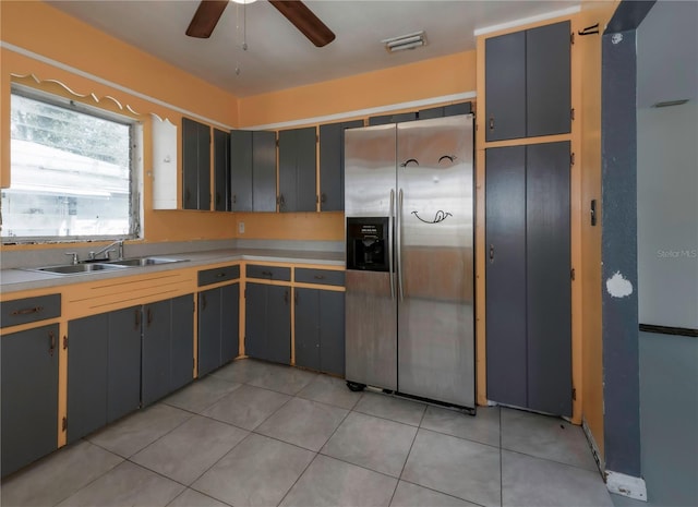 kitchen with gray cabinetry, sink, and stainless steel fridge