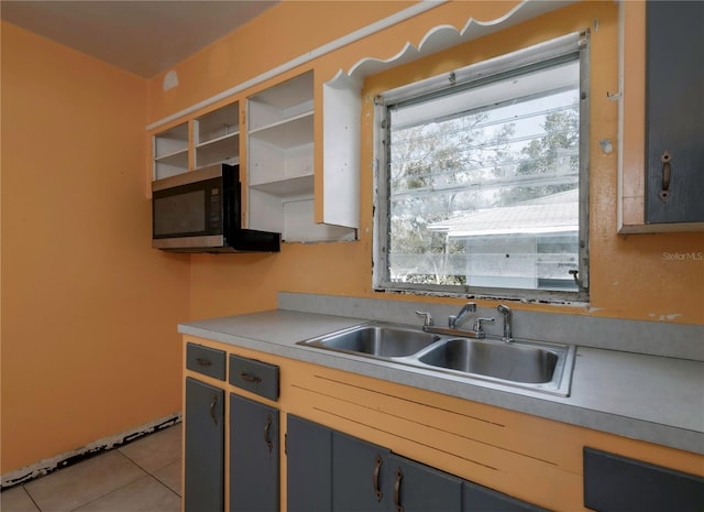 kitchen featuring light tile patterned floors, sink, and gray cabinetry