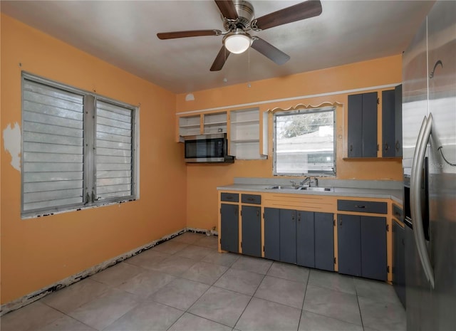 kitchen featuring appliances with stainless steel finishes, sink, light tile patterned floors, and ceiling fan