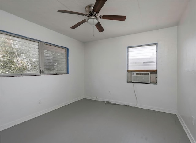 spare room featuring cooling unit, concrete floors, and ceiling fan