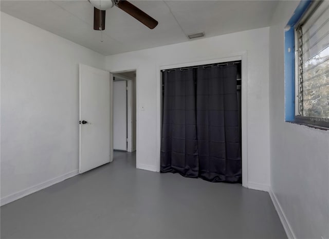 unfurnished bedroom with concrete flooring and ceiling fan