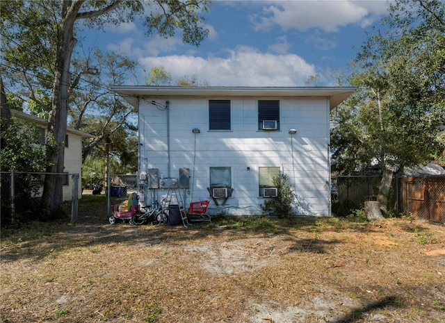 rear view of house with cooling unit and a yard