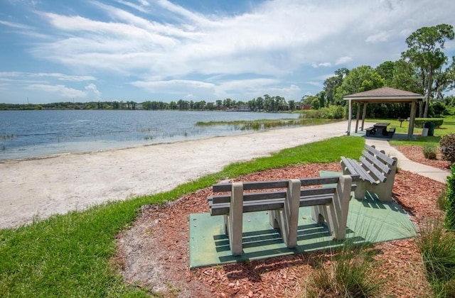 view of property's community with a water view, a beach view, and a gazebo