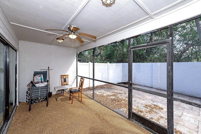 unfurnished sunroom featuring ceiling fan