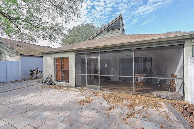 back of property with a sunroom and a patio