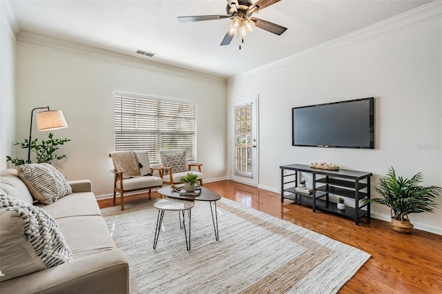 living room with ceiling fan, ornamental molding, and wood-type flooring