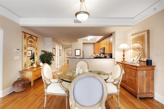 dining space featuring crown molding and light wood-type flooring