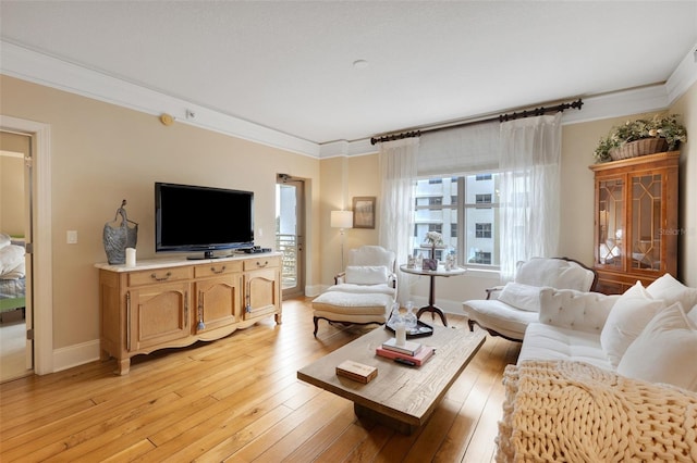 living room featuring crown molding and light hardwood / wood-style flooring