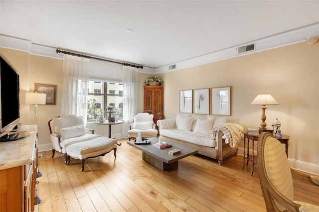 living room featuring crown molding and light hardwood / wood-style flooring