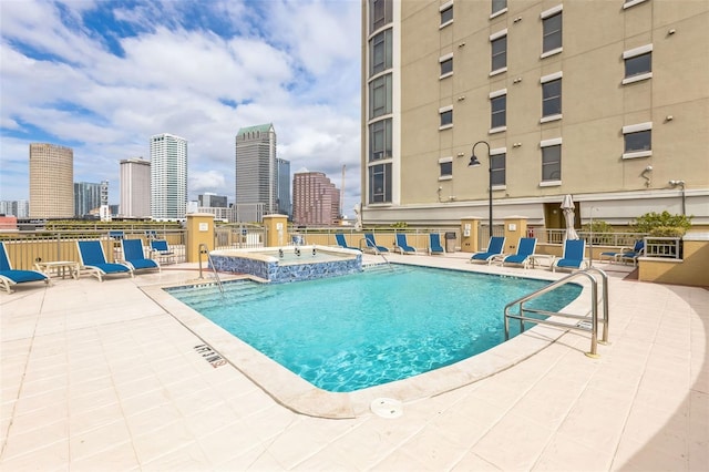 view of swimming pool featuring a community hot tub and a patio