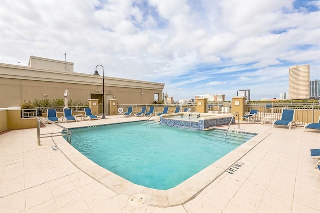 view of pool featuring a hot tub and a patio