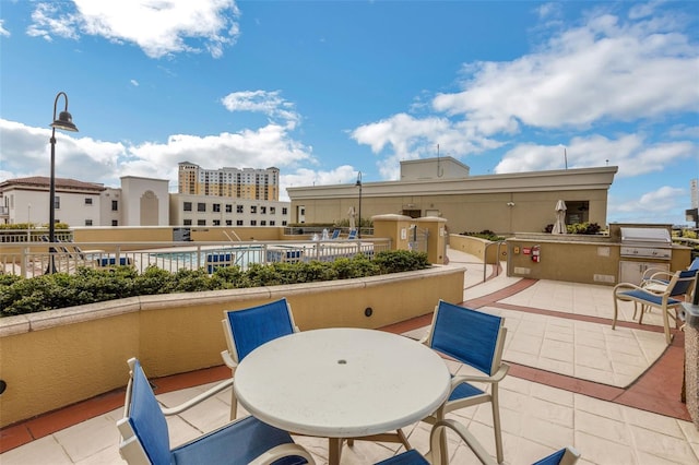 balcony featuring area for grilling, exterior kitchen, and a patio area