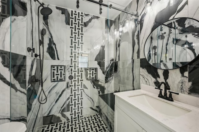 bathroom featuring vanity, a shower with door, and tile walls